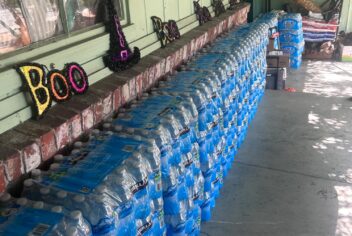 multiple cases of water stacked in front of a home