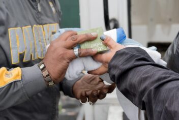 a towel and sundries being handed from one person to another