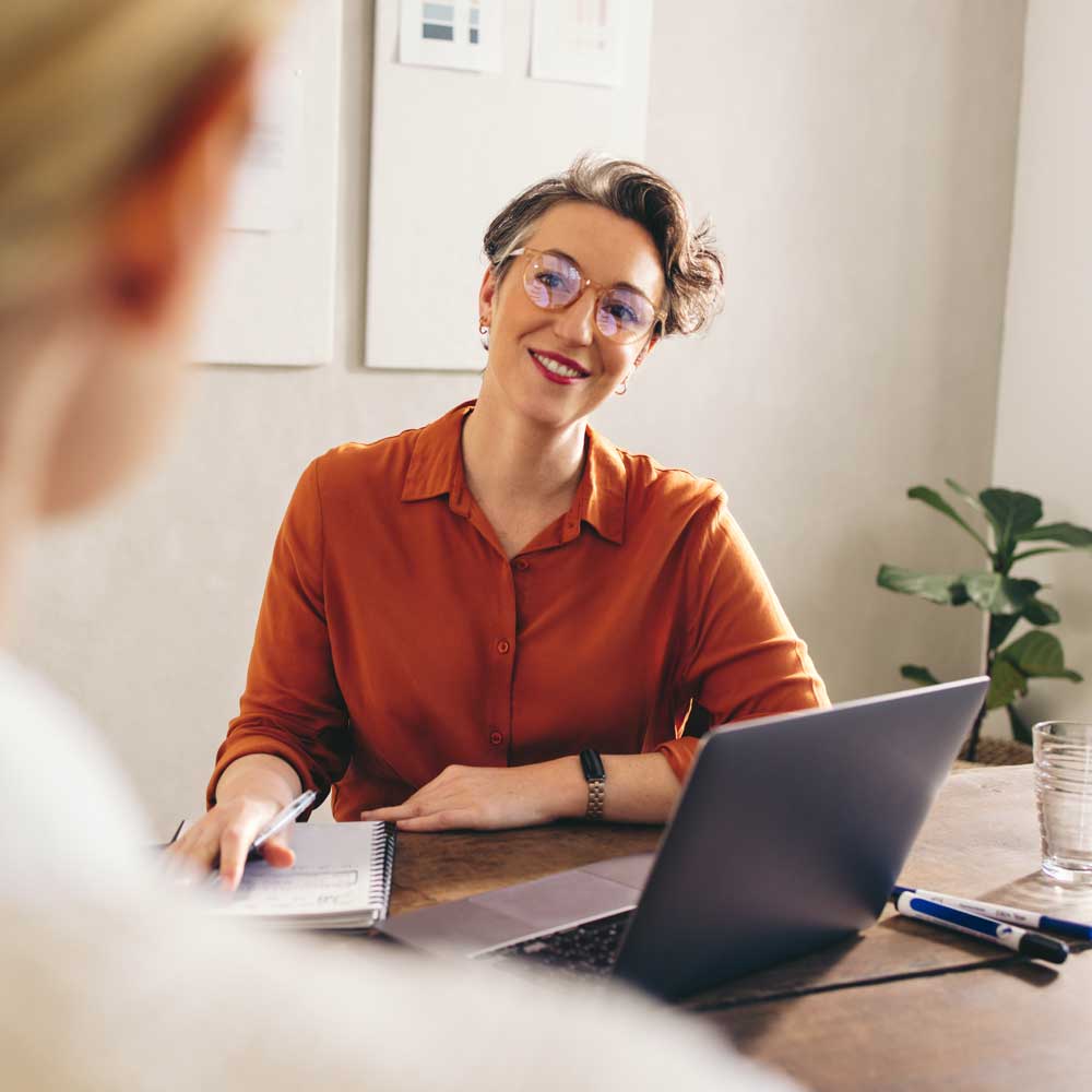 Woman sitting at a desk across from another
